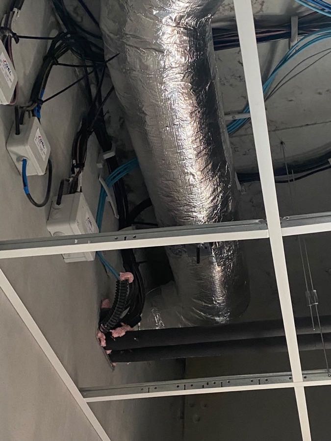 Gaine de ventilation calorifugée au-dessus d'une ossature de faux plafond